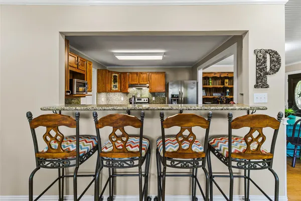 a dining hall with furniture and kitchen view