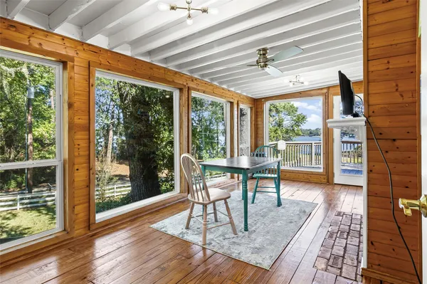 a dining room with wooden floor and a floor to ceiling window