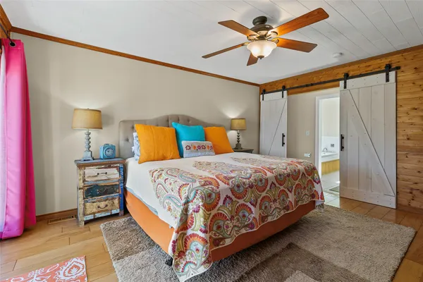 a bedroom with a bed and a ceiling fan