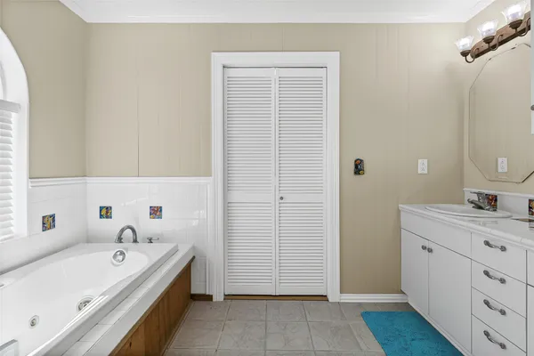 a bathroom with a tub sink and mirror