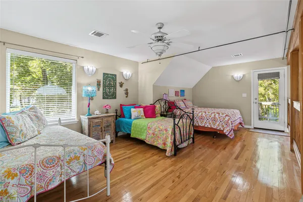 a bedroom with a bed chandelier and a window