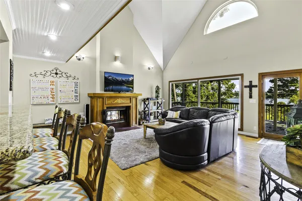 a living room with furniture a fireplace and a floor to ceiling window