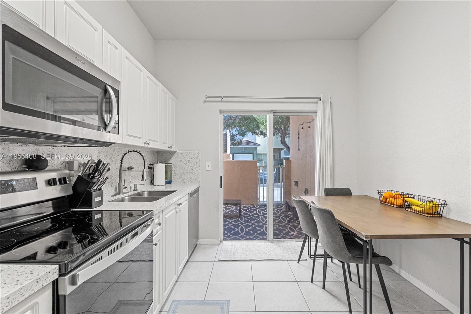 1940 Southeast 24th Terrace Homestead, FL 33035 - Photo 2 of 29 a kitchen with stainless steel appliances a table and chairs in it