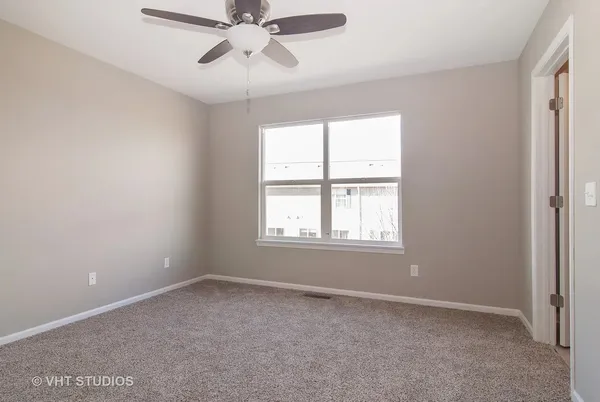 an empty room with a window and a fan