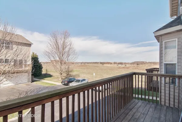 a view of a balcony with wooden floor and fence