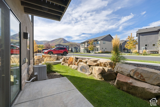 1141 520 West Midway, UT 84049 - Photo 24 of 40 Outdoor patio with concrete pavers, stone veneer siding, and a landscaped rock retaining wall