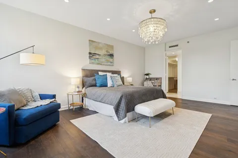 a bedroom with a large bed and a chandelier