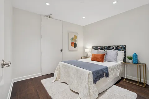 a bedroom with a bed and wooden floor