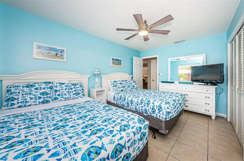 6020 Midnight Pass Road, Unit 14A Sarasota, FL 34242 - Photo 13 of 18 a bedroom with a large bed and a chandelier