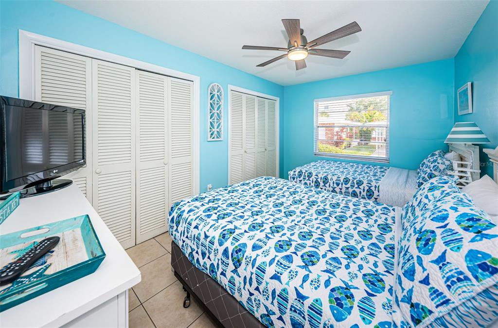 6020 Midnight Pass Road, Unit 14A Sarasota, FL 34242 - Photo 14 of 18 a bedroom with a bed and a flat screen tv