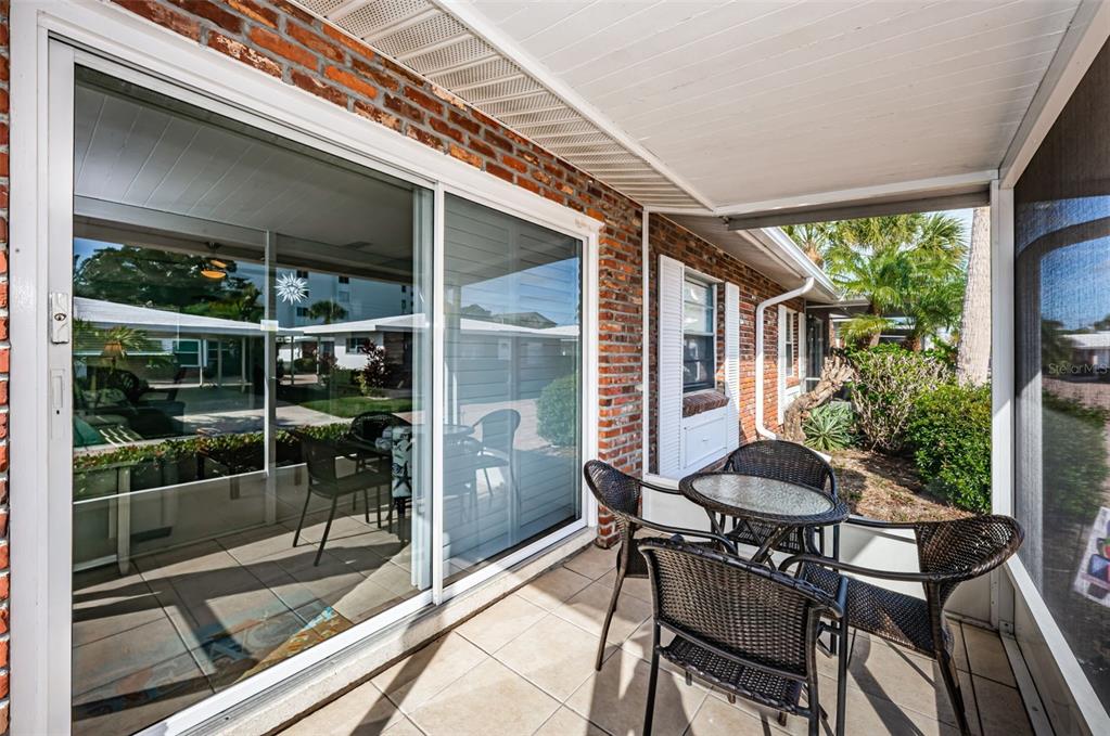 6020 Midnight Pass Road, Unit 14A Sarasota, FL 34242 - Photo 5 of 18 a patio with table and chairs and potted plants
