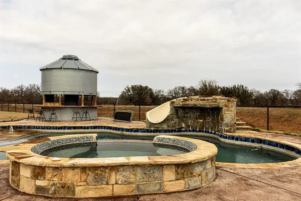 a view of a house with swimming pool and a yard