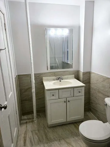 a bathroom with a sink a toilet and mirror