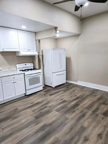 a kitchen with white cabinets and white appliances