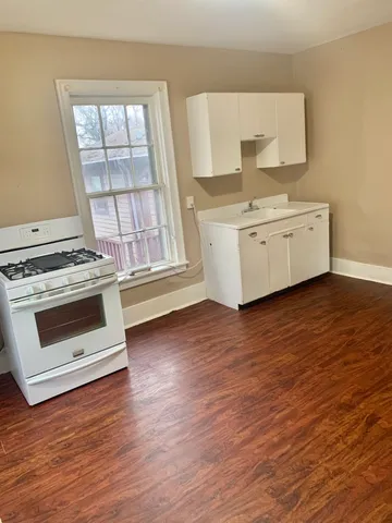 a view of kitchen with wooden floor and electronic appliances