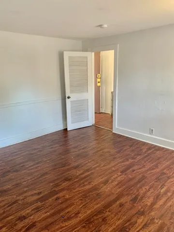 a view of a room with wooden floor and window