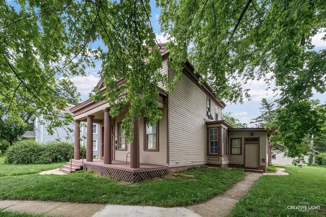a front view of a house with a yard and trees
