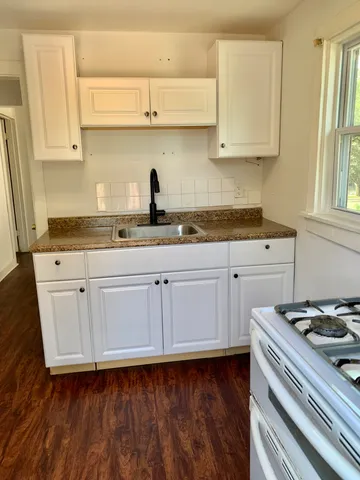 a kitchen with granite countertop a sink and cabinets