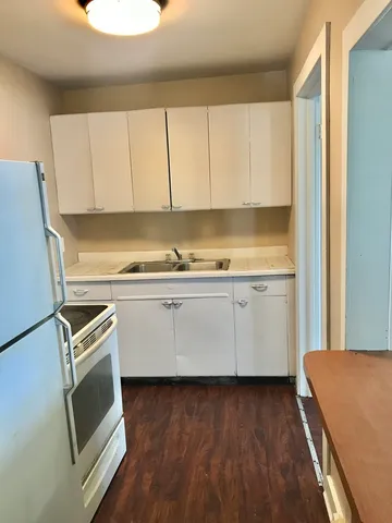 a kitchen with granite countertop white cabinets and white appliances