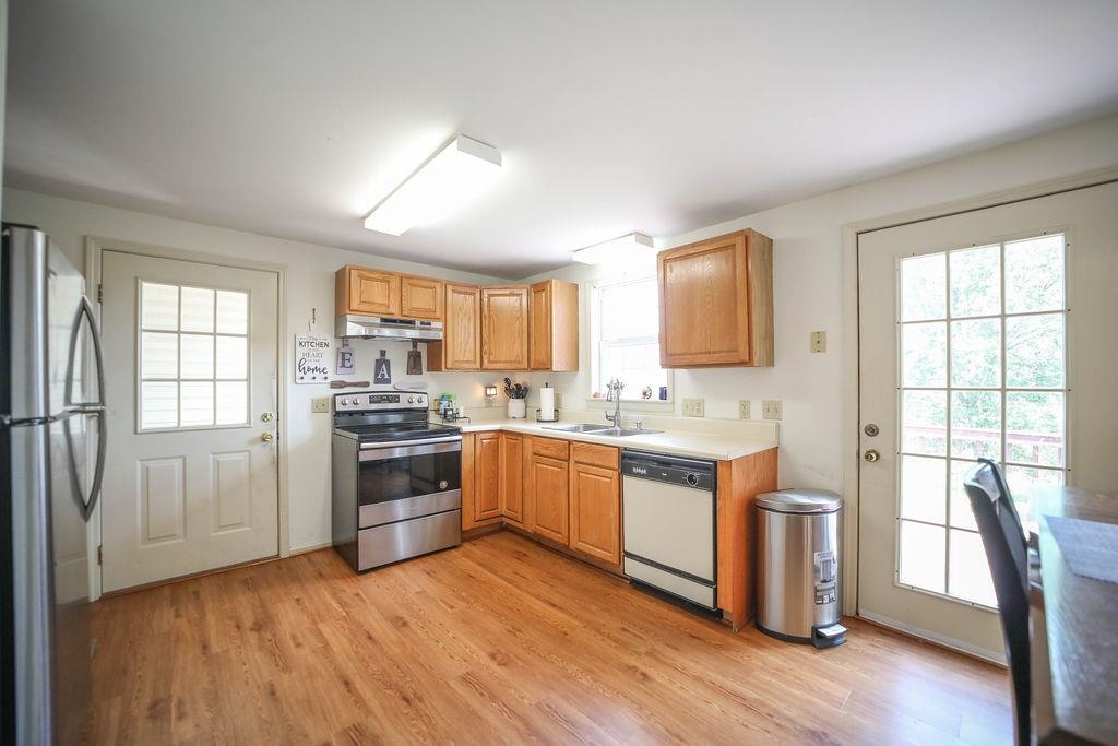 79 Cattle Scales Road Waynesboro, VA 22980 - Photo 12 of 39 a large kitchen with a stove a sink dishwasher a refrigerator and white cabinets with wooden floor