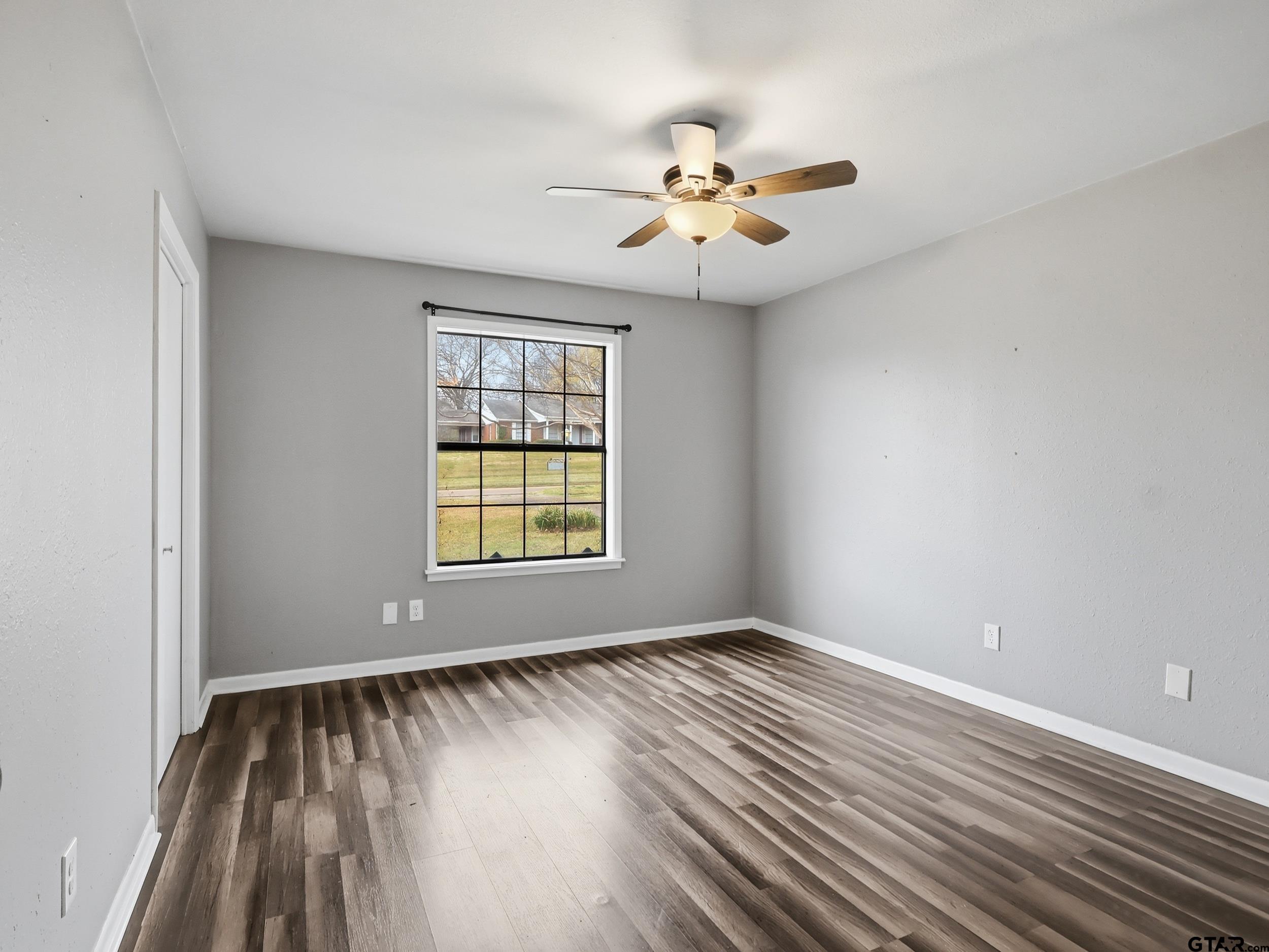 231 Quitman Street Pittsburg, TX 75686 - Photo 18 of 31 a view of an empty room with wooden floor and a window