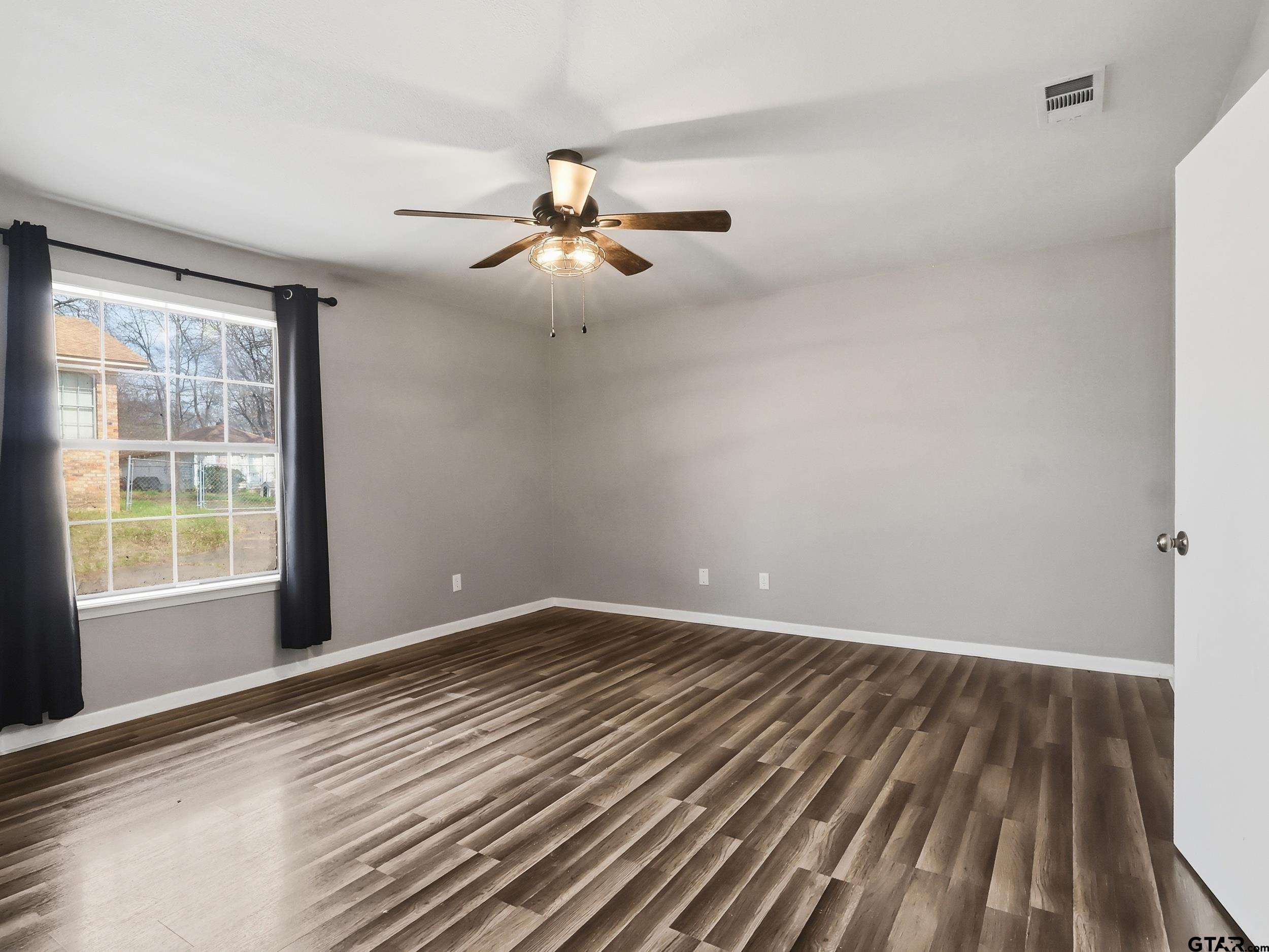 231 Quitman Street Pittsburg, TX 75686 - Photo 21 of 31 a view of empty room with wooden floor and fan