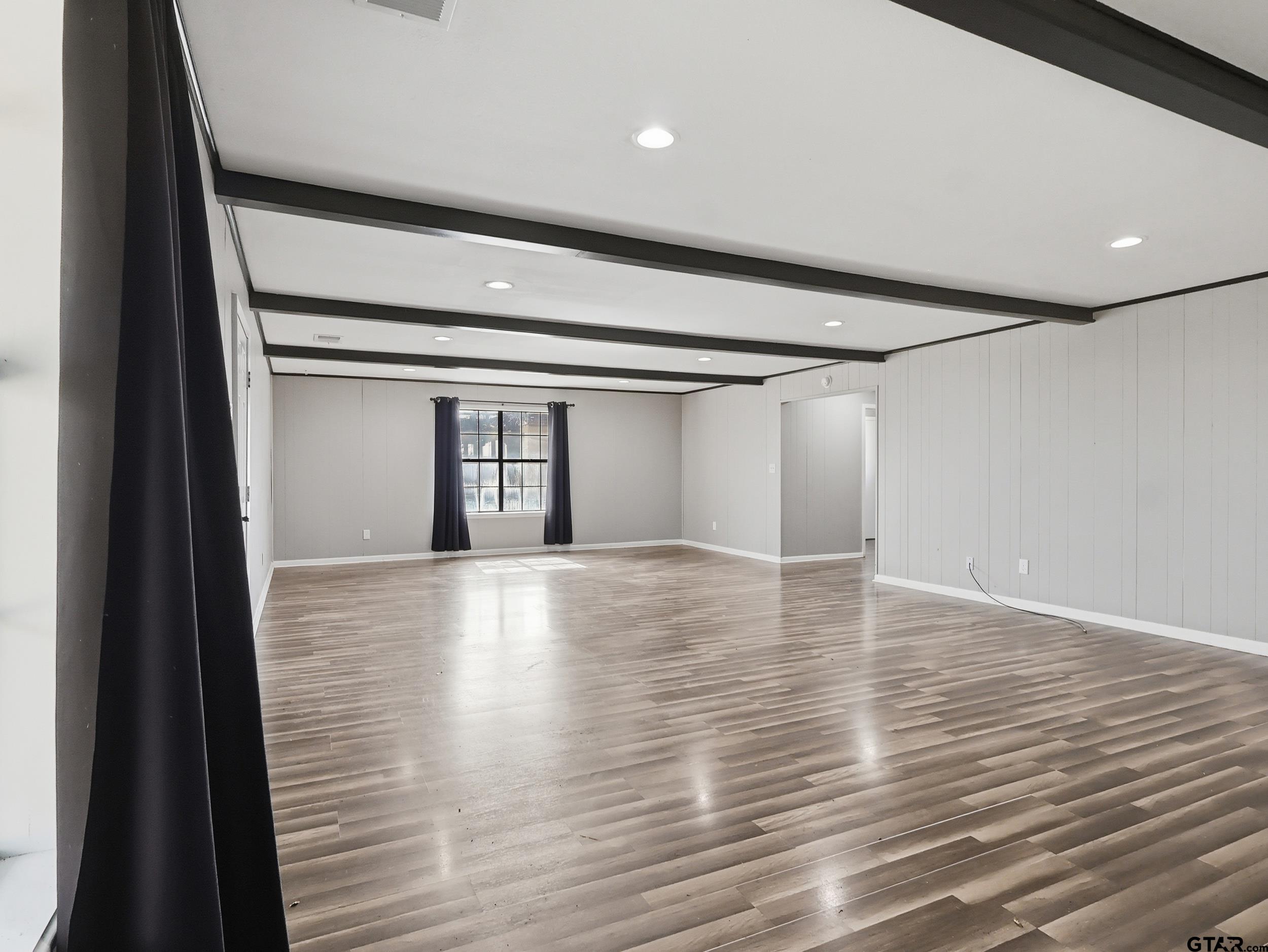 231 Quitman Street Pittsburg, TX 75686 - Photo 23 of 31 a view of an empty room with wooden floor
