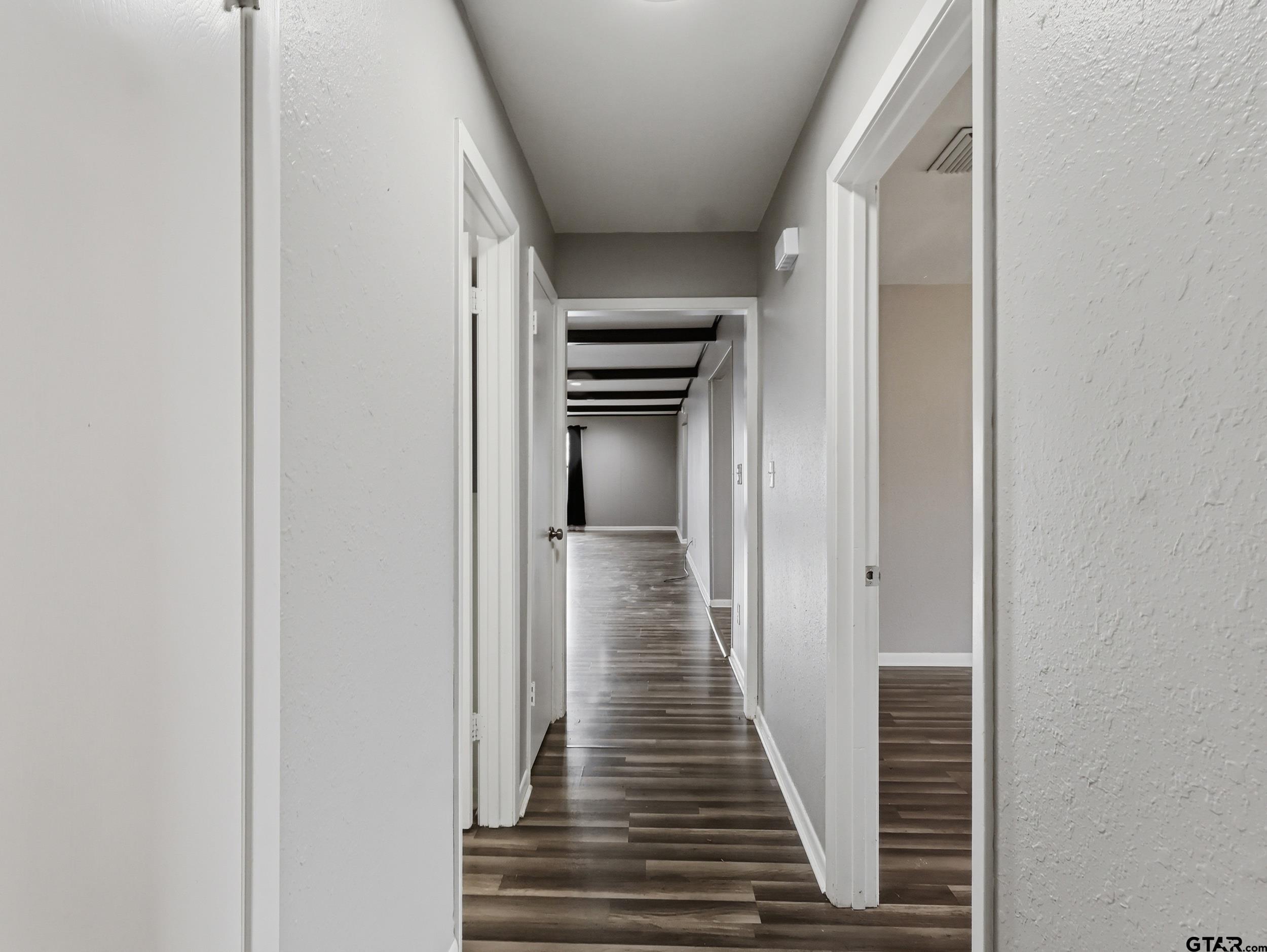 231 Quitman Street Pittsburg, TX 75686 - Photo 26 of 31 a view of a hallway with wooden floor and staircase