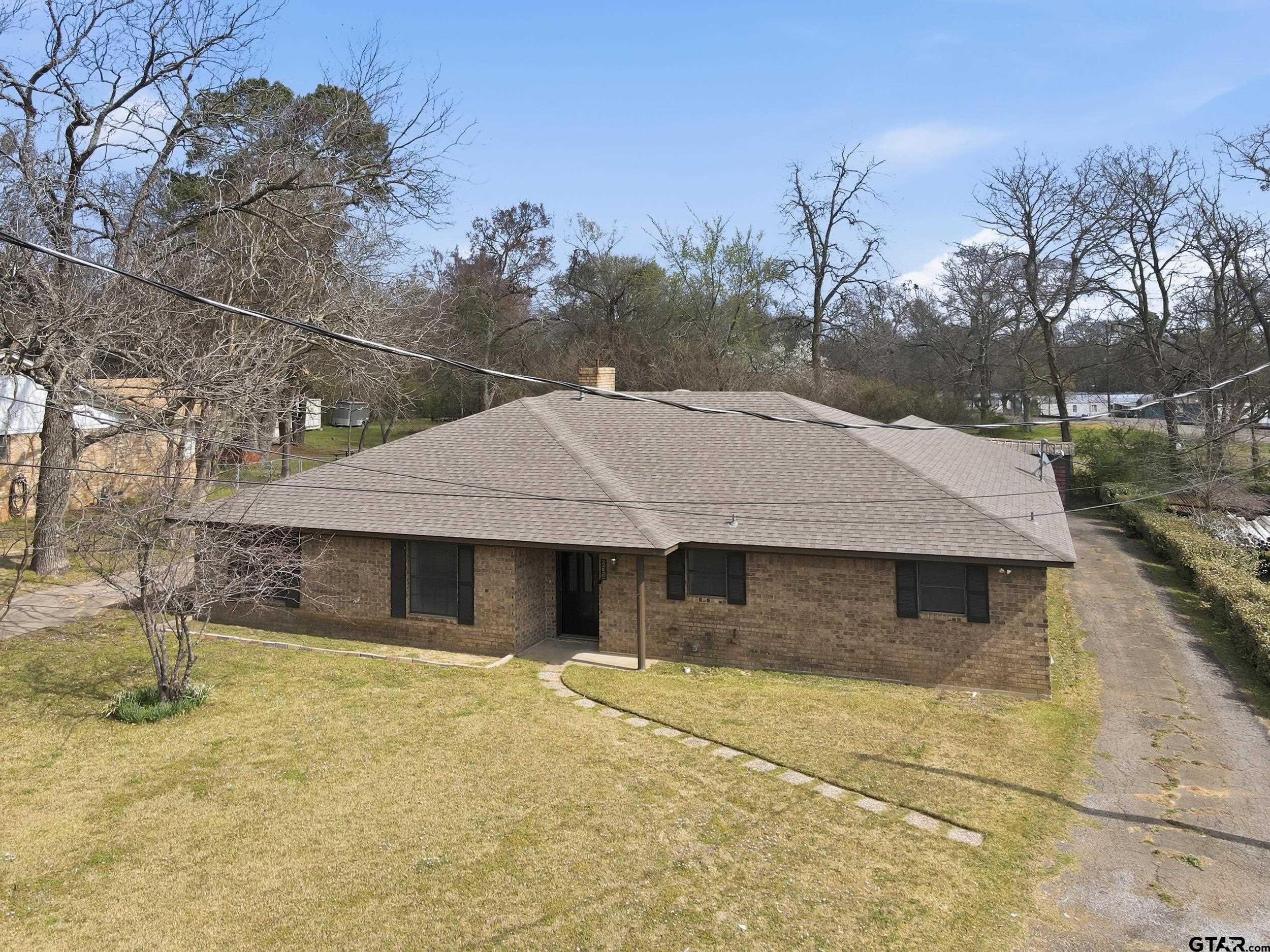 231 Quitman Street Pittsburg, TX 75686 - Photo 27 of 31 a house with trees in the background