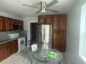 a kitchen with stainless steel appliances granite countertop a refrigerator a stove and a sink with wooden floor