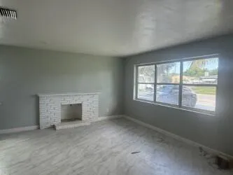 an empty room with fireplace and windows