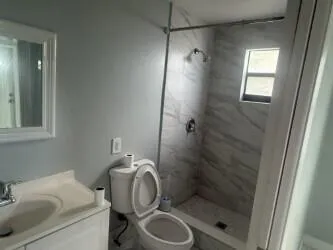 a bathroom with a sink toilet and shower