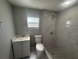 a bathroom with a toilet sink and mirror