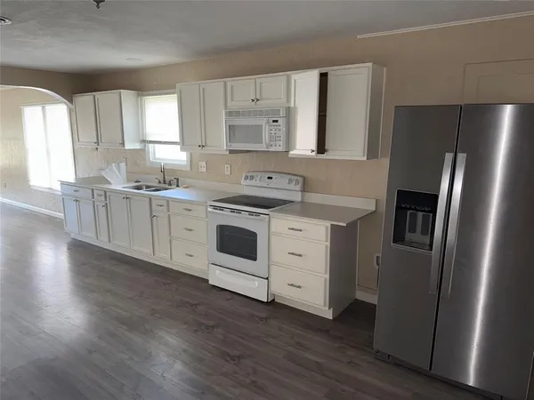 a kitchen with stainless steel appliances a stove a refrigerator and cabinets