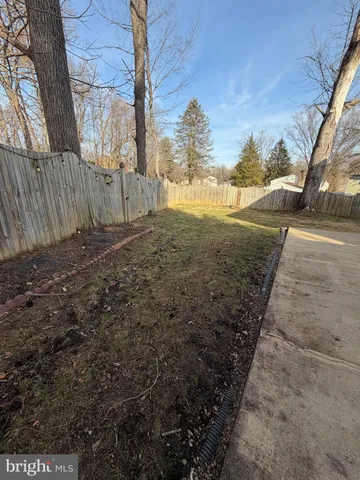 a view of a yard with wooden fence