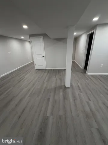 an empty room with wooden floor and entrance