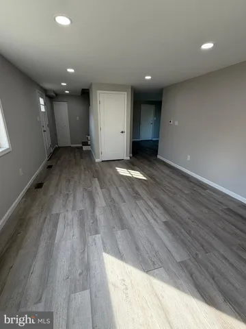 an empty room with wooden floor and natural light