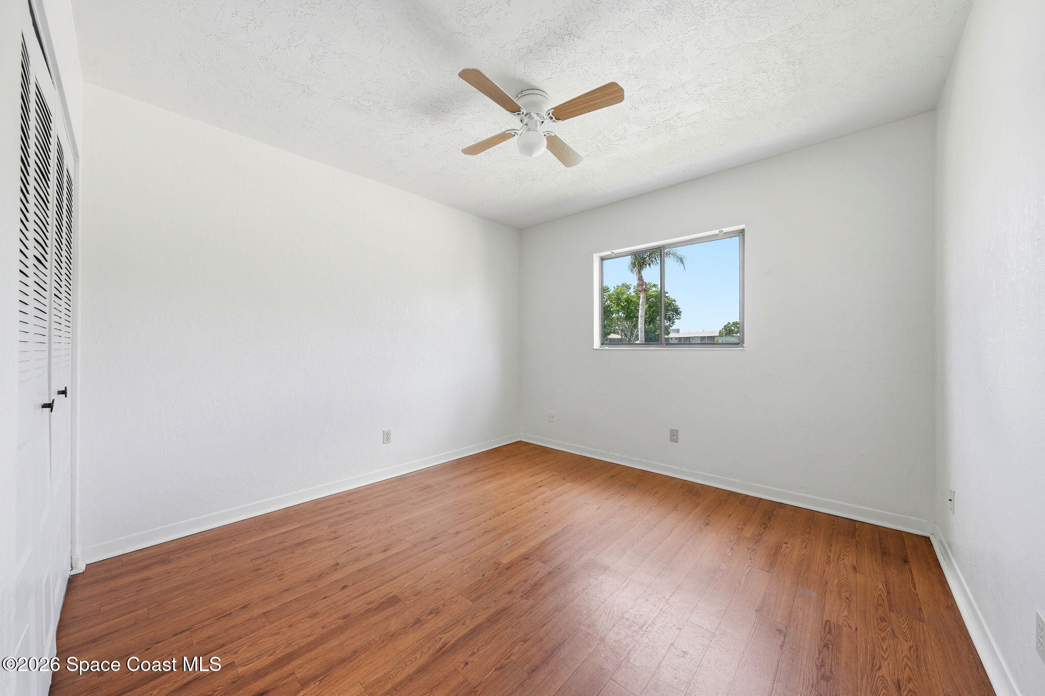 1702 University Lane, Unit 804 Cocoa, FL 32922 - Photo 14 of 25 an empty room with wooden floor and ceiling fan
