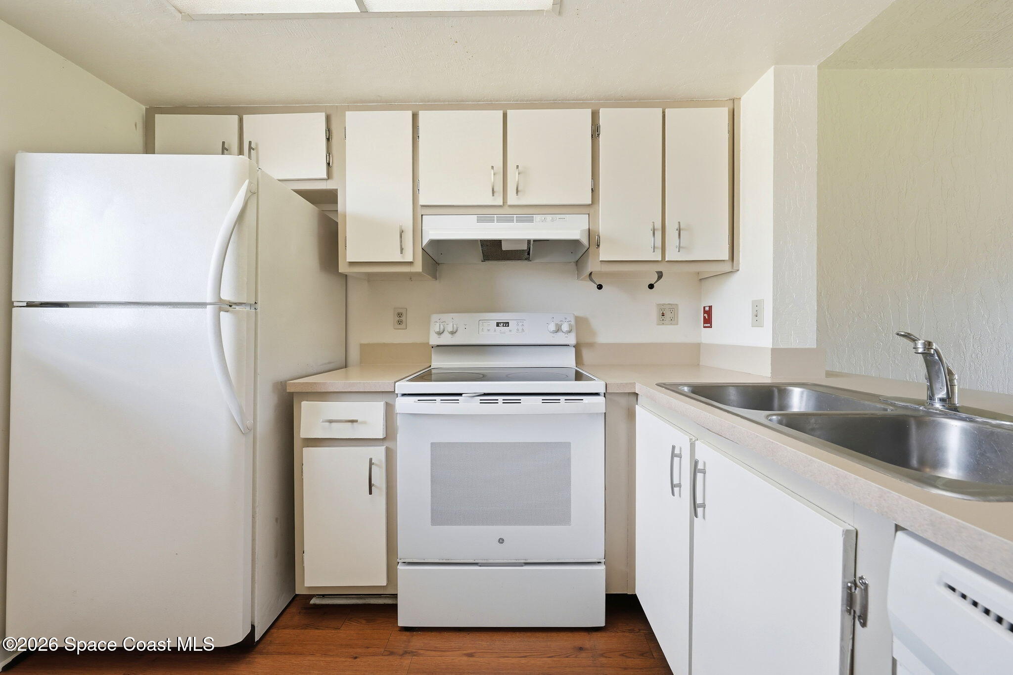 1702 University Lane, Unit 804 Cocoa, FL 32922 - Photo 5 of 25 a kitchen with a white cabinets and white appliances