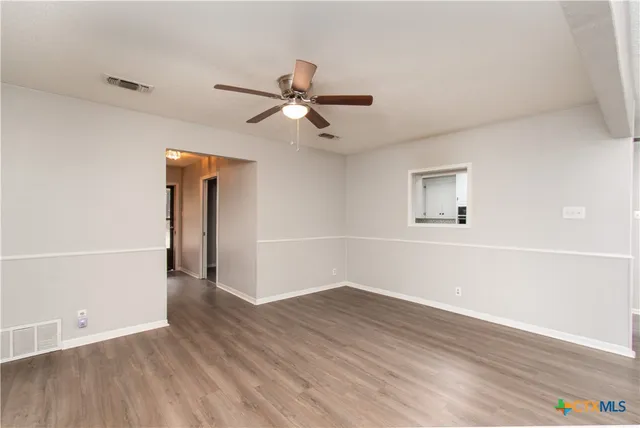wooden floor in an empty room with a window