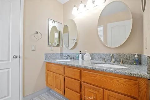 a bathroom with a granite countertop double vanity sinks and a mirror