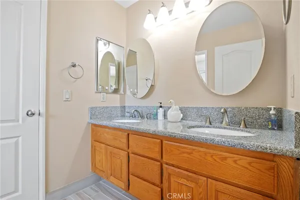 a bathroom with a granite countertop double vanity sinks and a mirror
