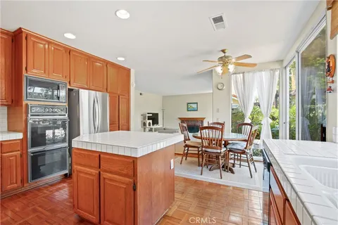a dining hall with stainless steel appliances granite countertop a stove and a dining table