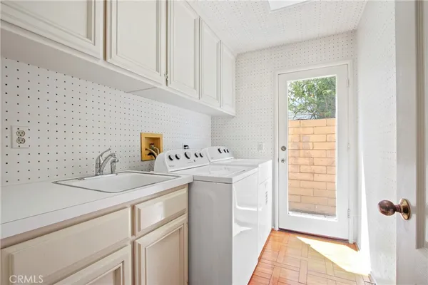 a utility room with cabinets washer and dryer