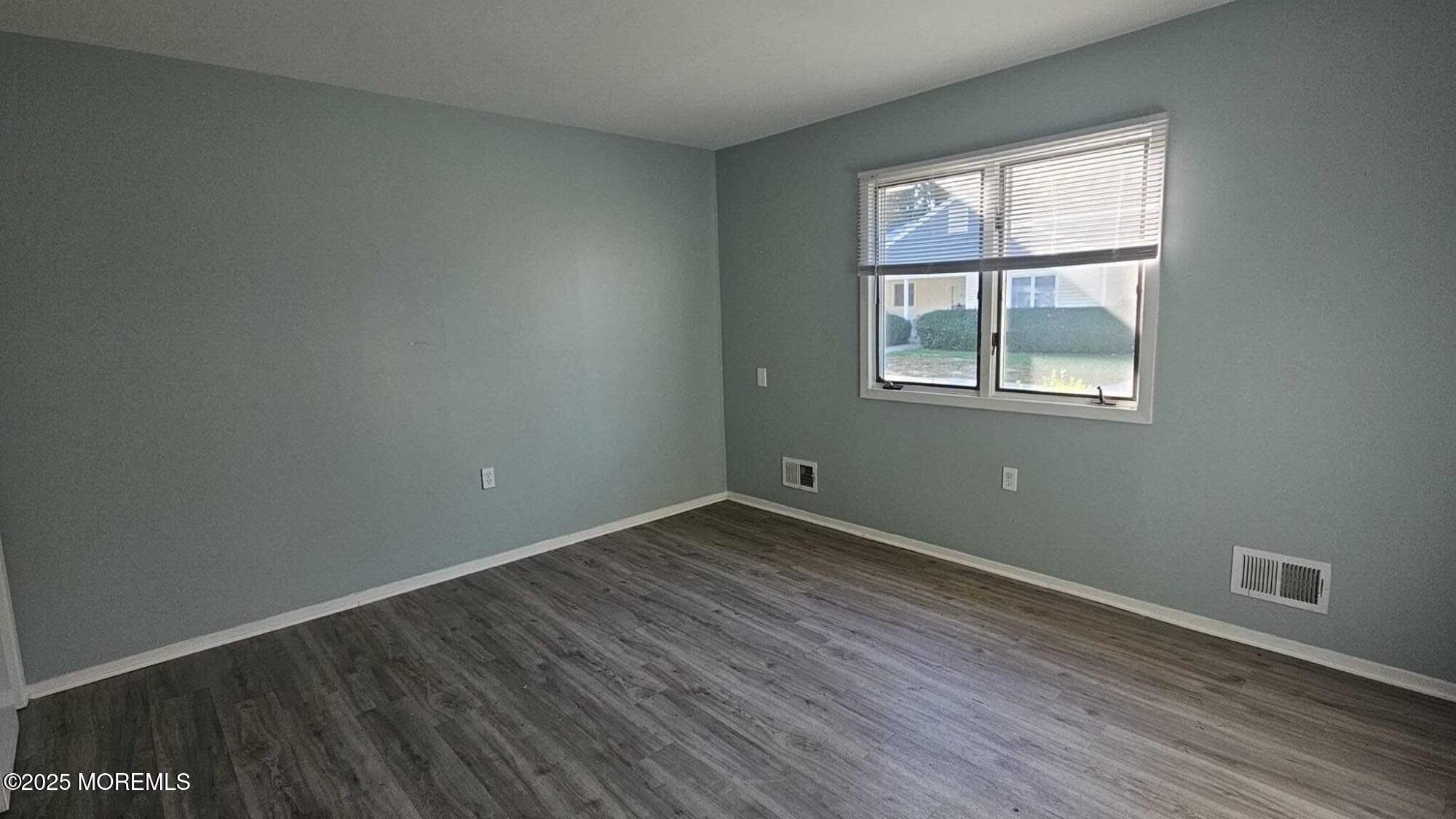 1700 Highway 37, Unit 10206 Toms River, NJ 08757 - Photo 4 of 9 an empty room with wooden floor and windows