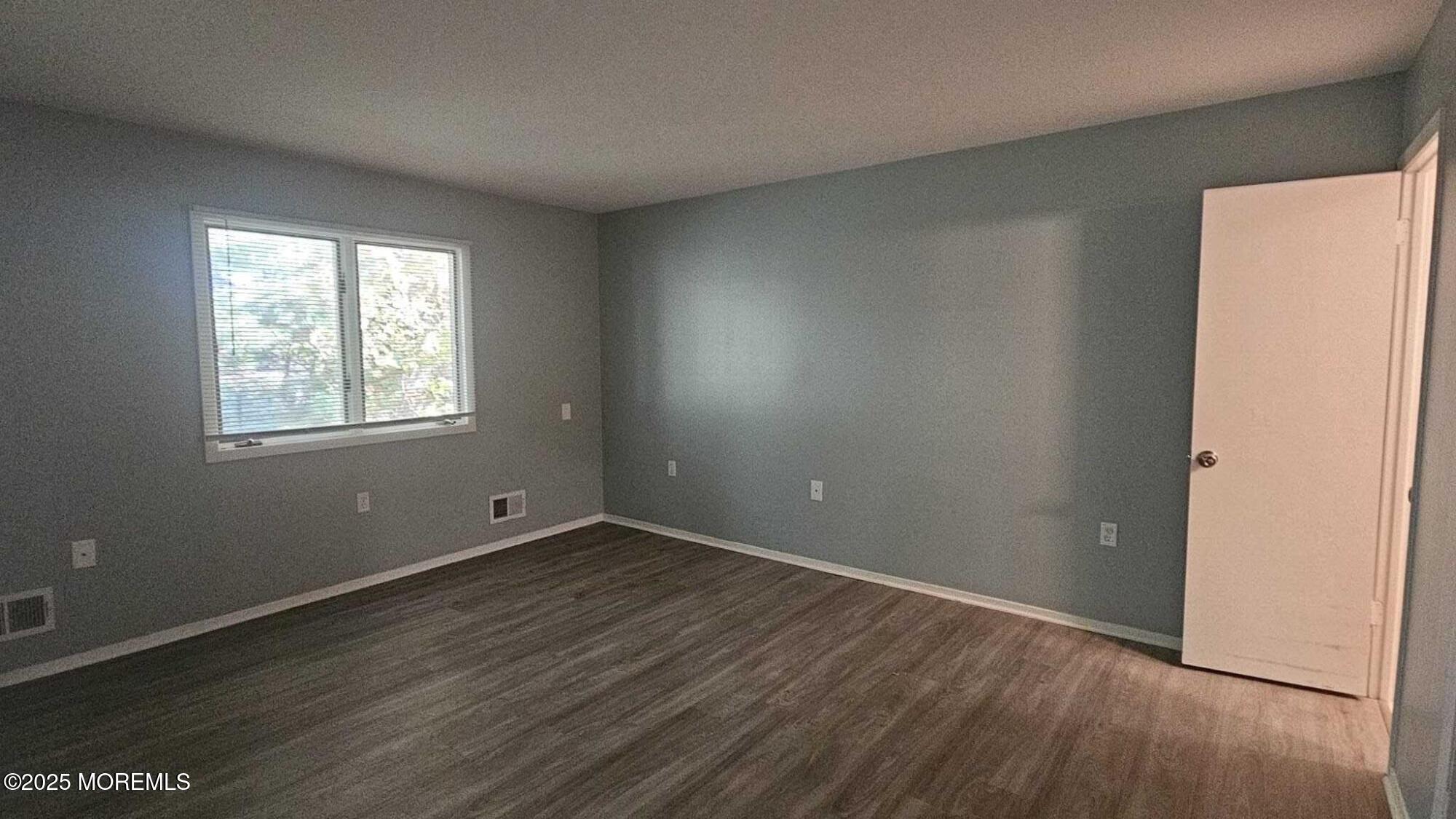 1700 Highway 37, Unit 10206 Toms River, NJ 08757 - Photo 7 of 9 an empty room with wooden floor and windows