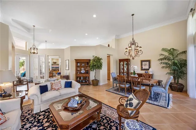 a living room with furniture a chandelier and a table