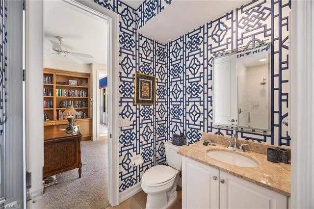 a bathroom with a granite countertop toilet a sink and a mirror