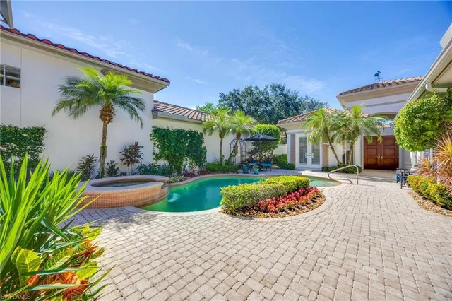 a front view of a house with a garden and swimming pool