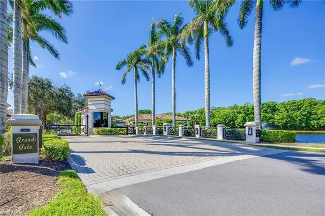 a view of a tall building with a yard and palm trees